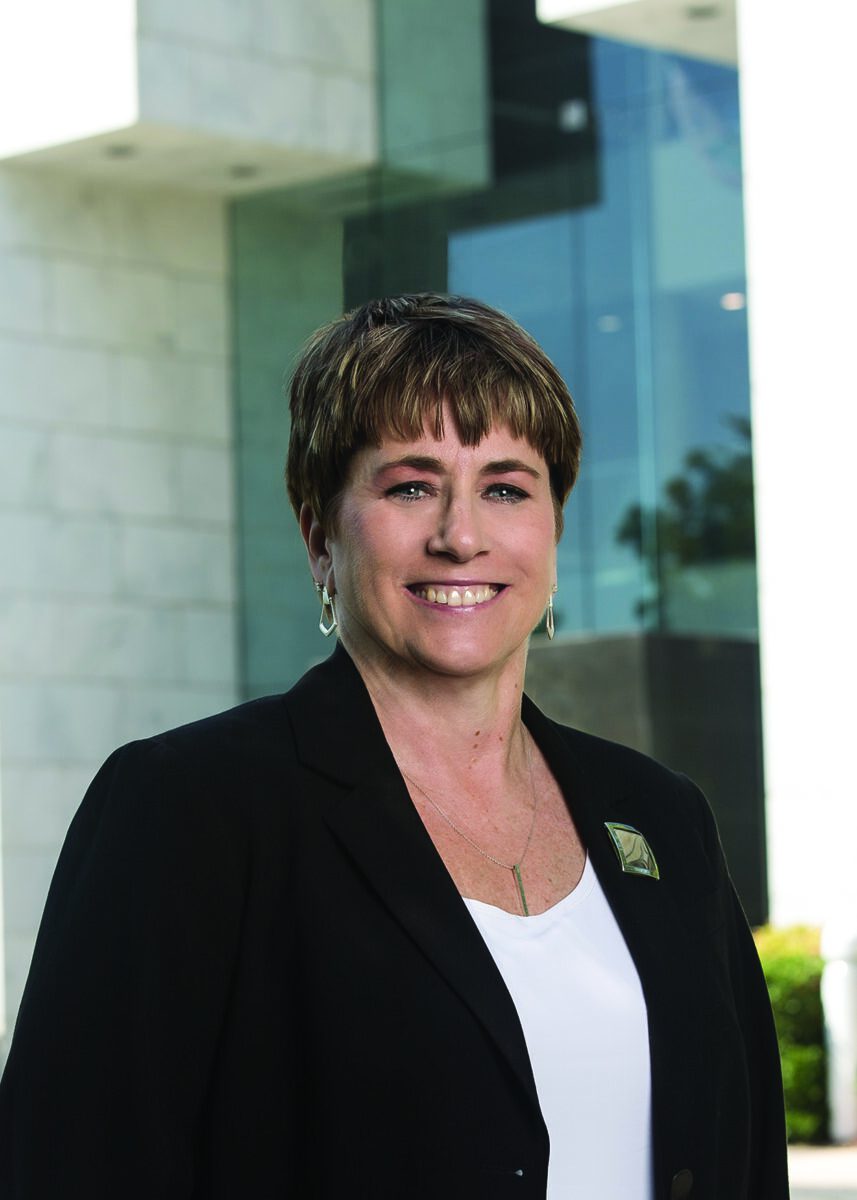 Professional woman smiling at Ceramics Industry event, promoting ceramic arts and engineering.