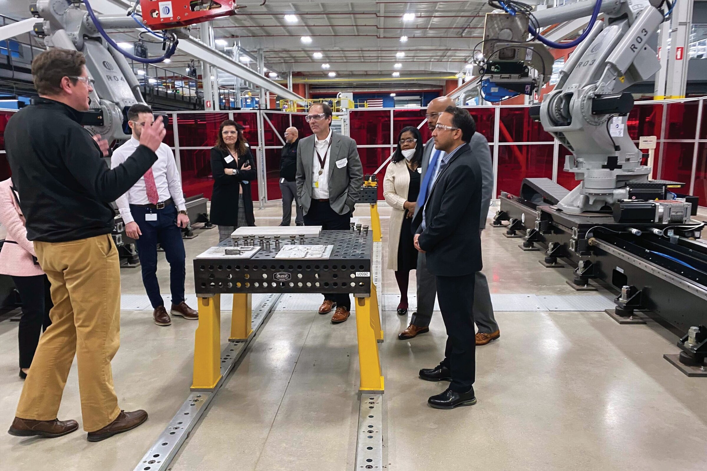 Ceramics industry professionals touring advanced manufacturing equipment at a ceramic research facility.