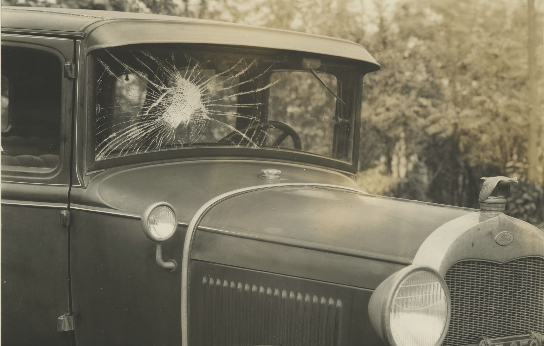 An early safety feature adopted by car manufacturers was laminated windshield glass. Introduced in the late 1920s, laminated glass kept glass shards in place after impact. This 1931 photograph shows the shattered laminated windshield of a Ford Model A. <em> Credit: Collections of The Henry Ford (Gift of Ford Motor Company)</em>