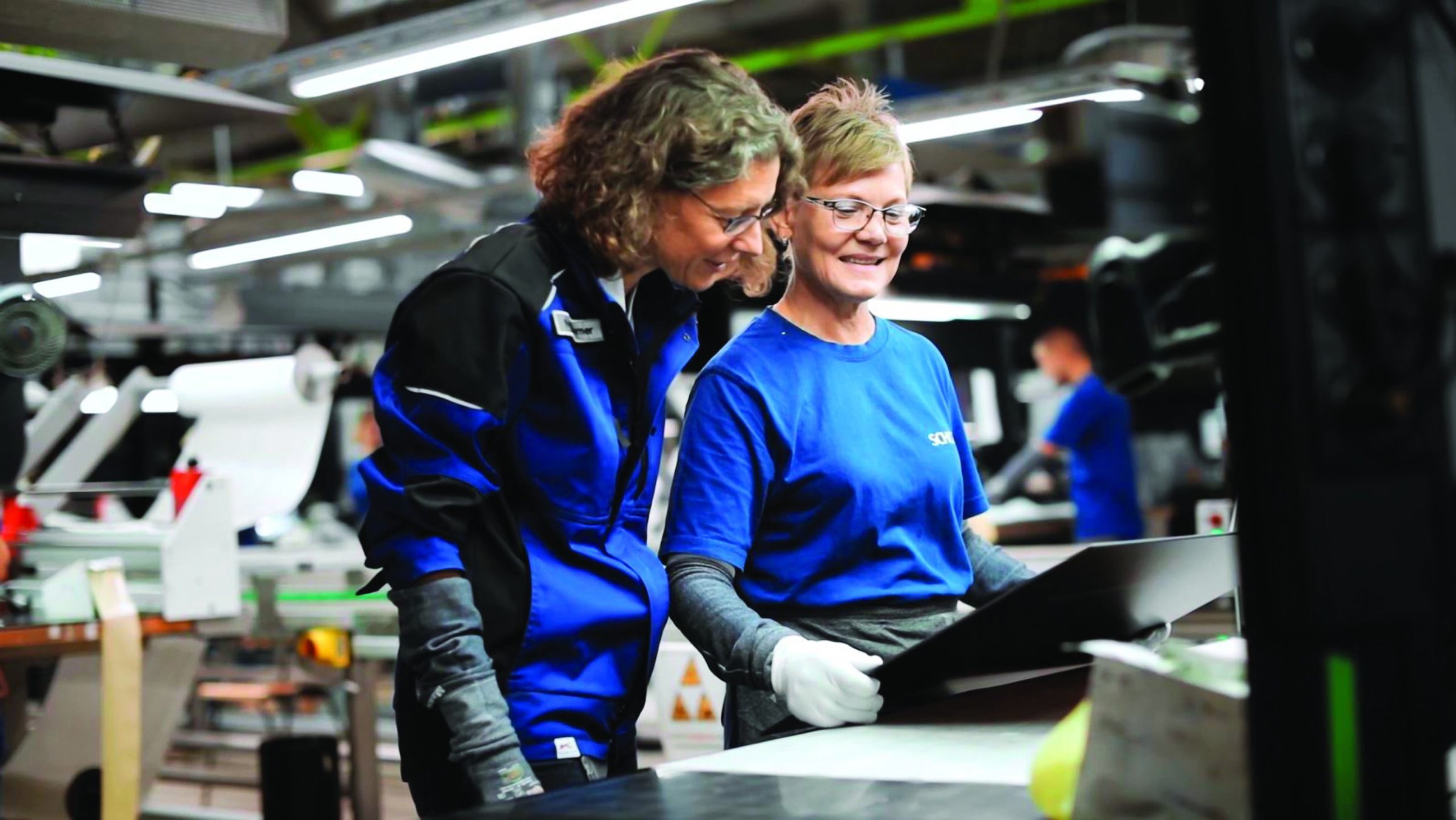Two women inspecting machinery.