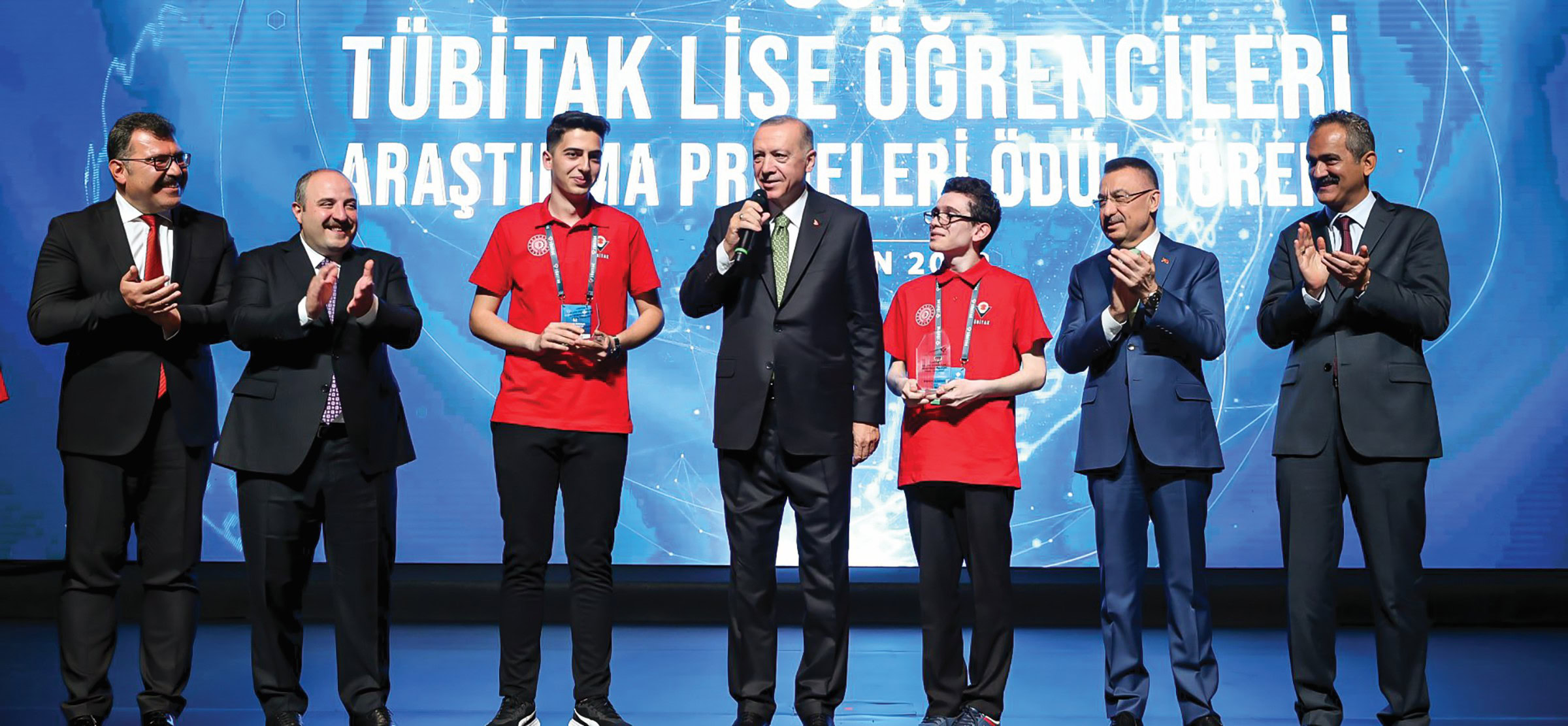High school students stand in a line to receive their award.