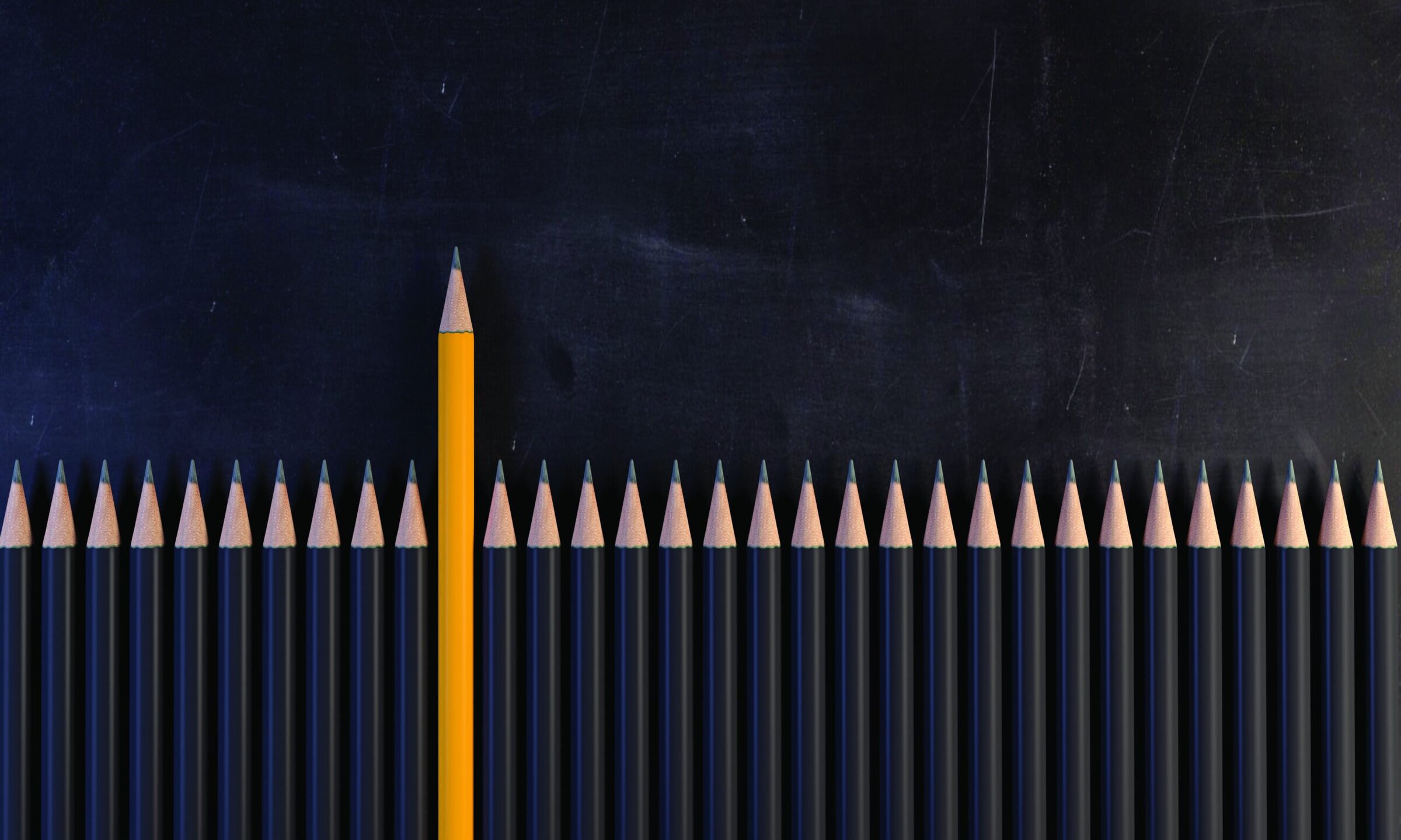 Orange Colored Pencil Standing Out From The Crowd