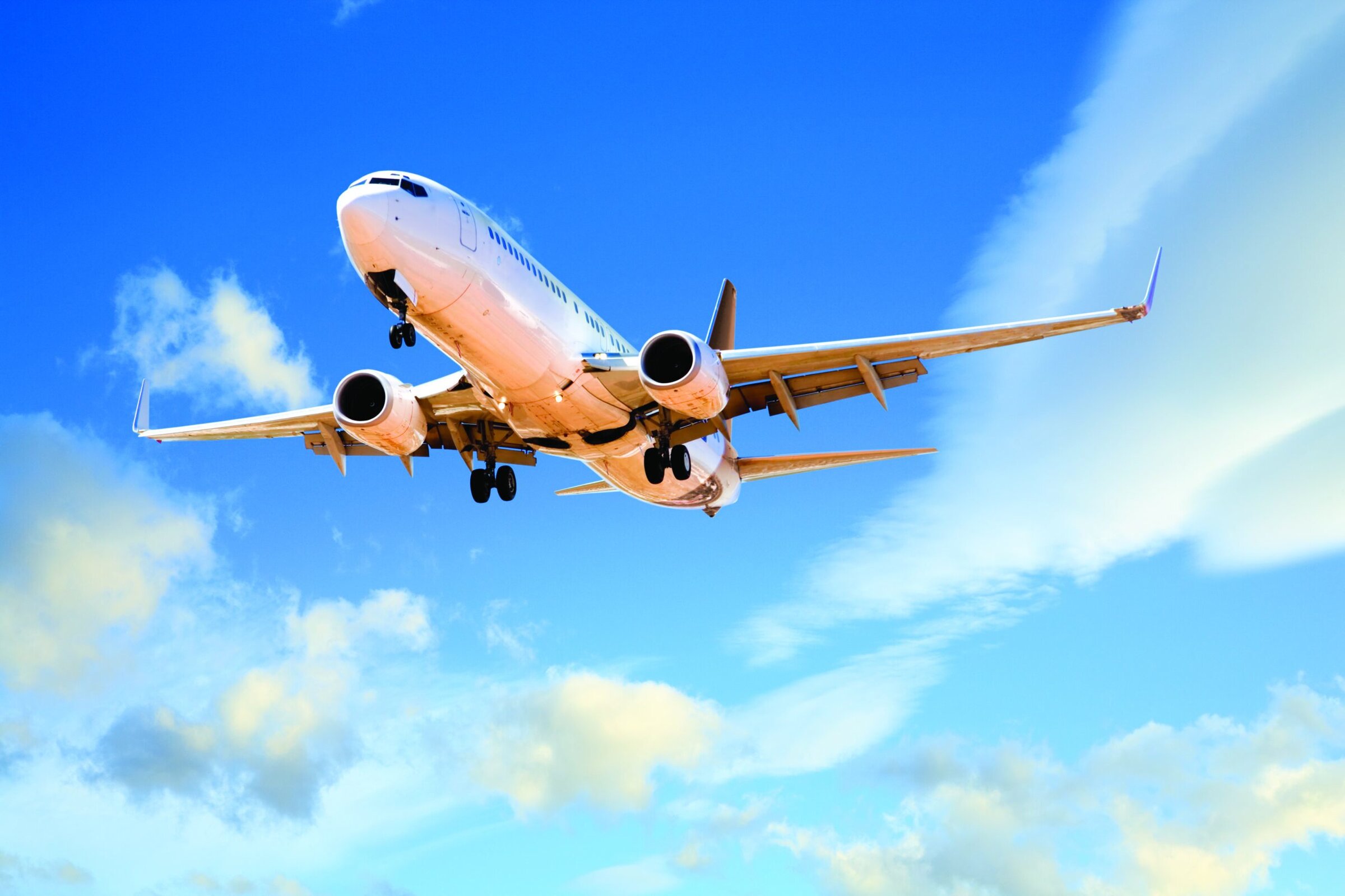 Airplane flying in blue sky with clouds, aircraft in flight, commercial jet, aviation, transportation, aerospace, modern aircraft.