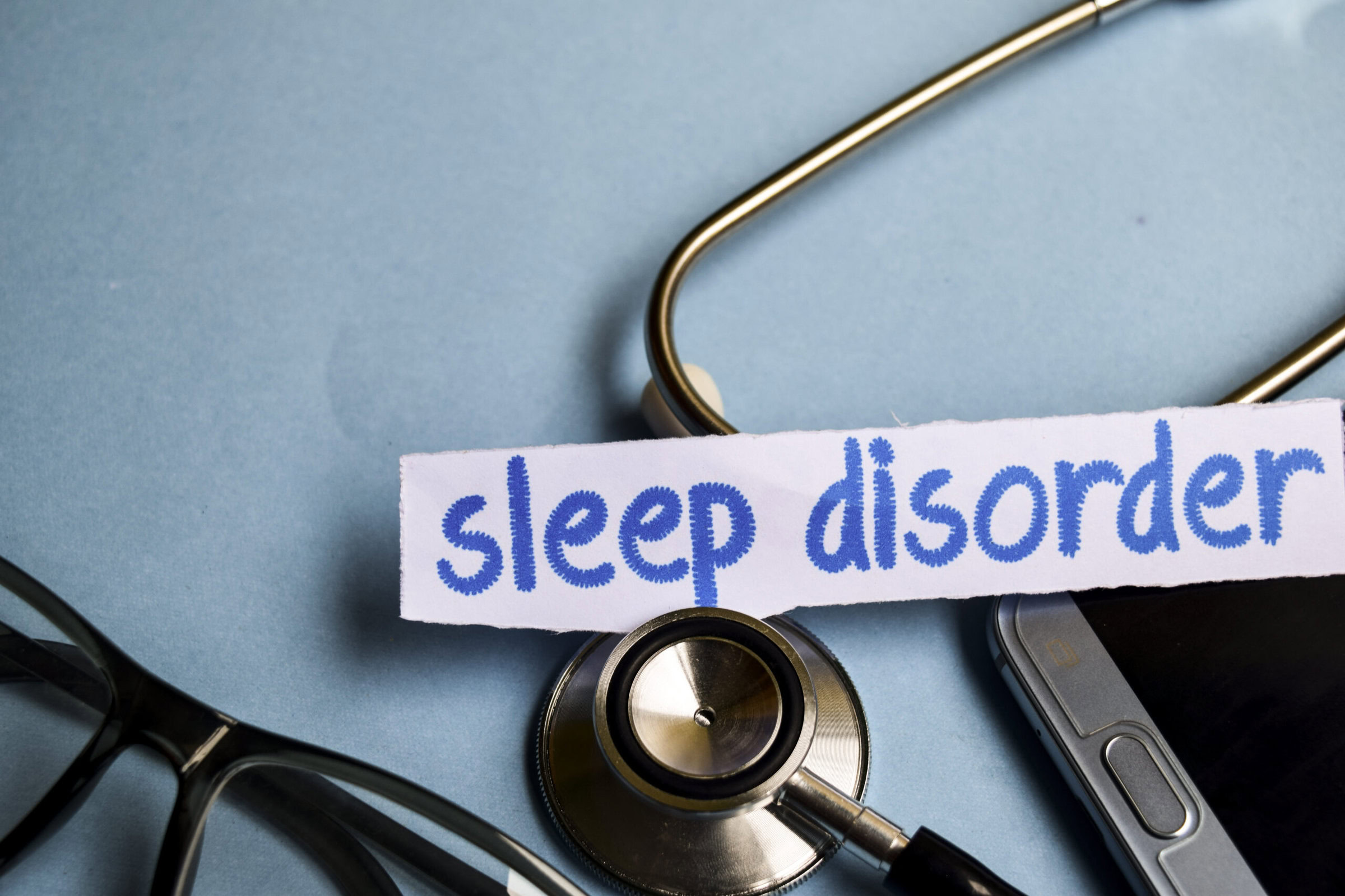 Stethoscope with the words "sleep disorder" written on a strip of paper on top.