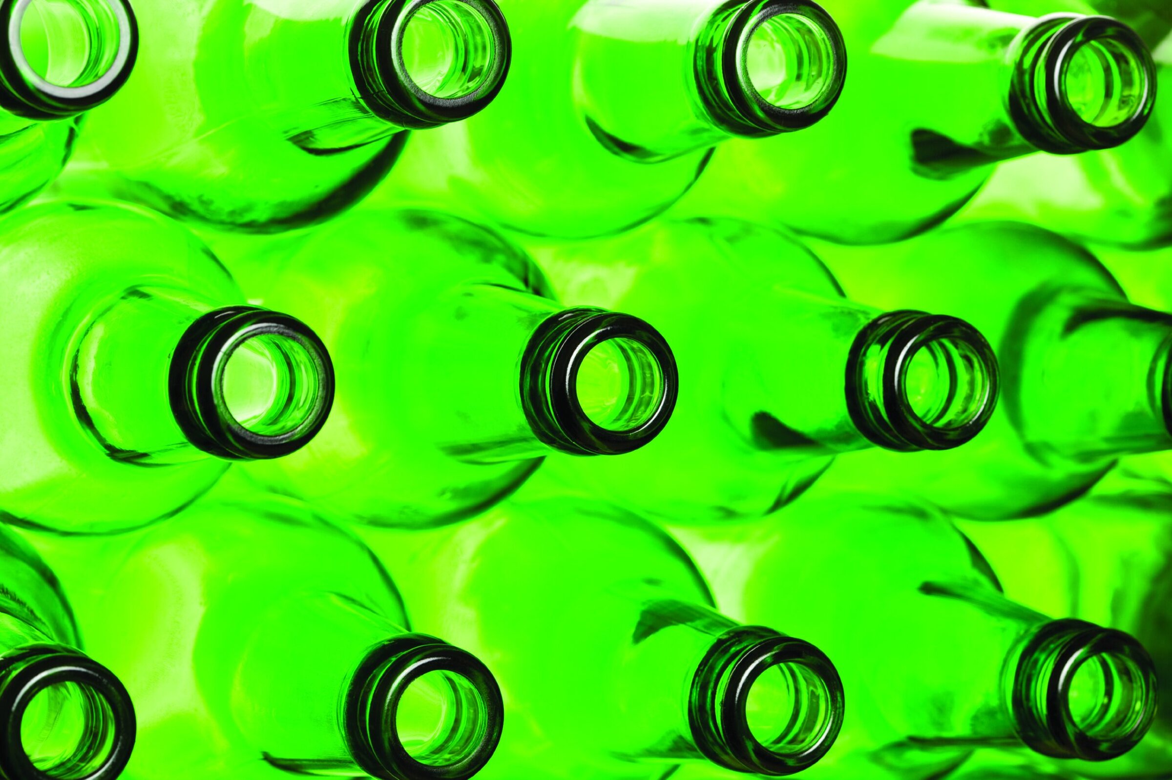 Green glass bottles arranged in a pattern for recycling and sustainability themes.