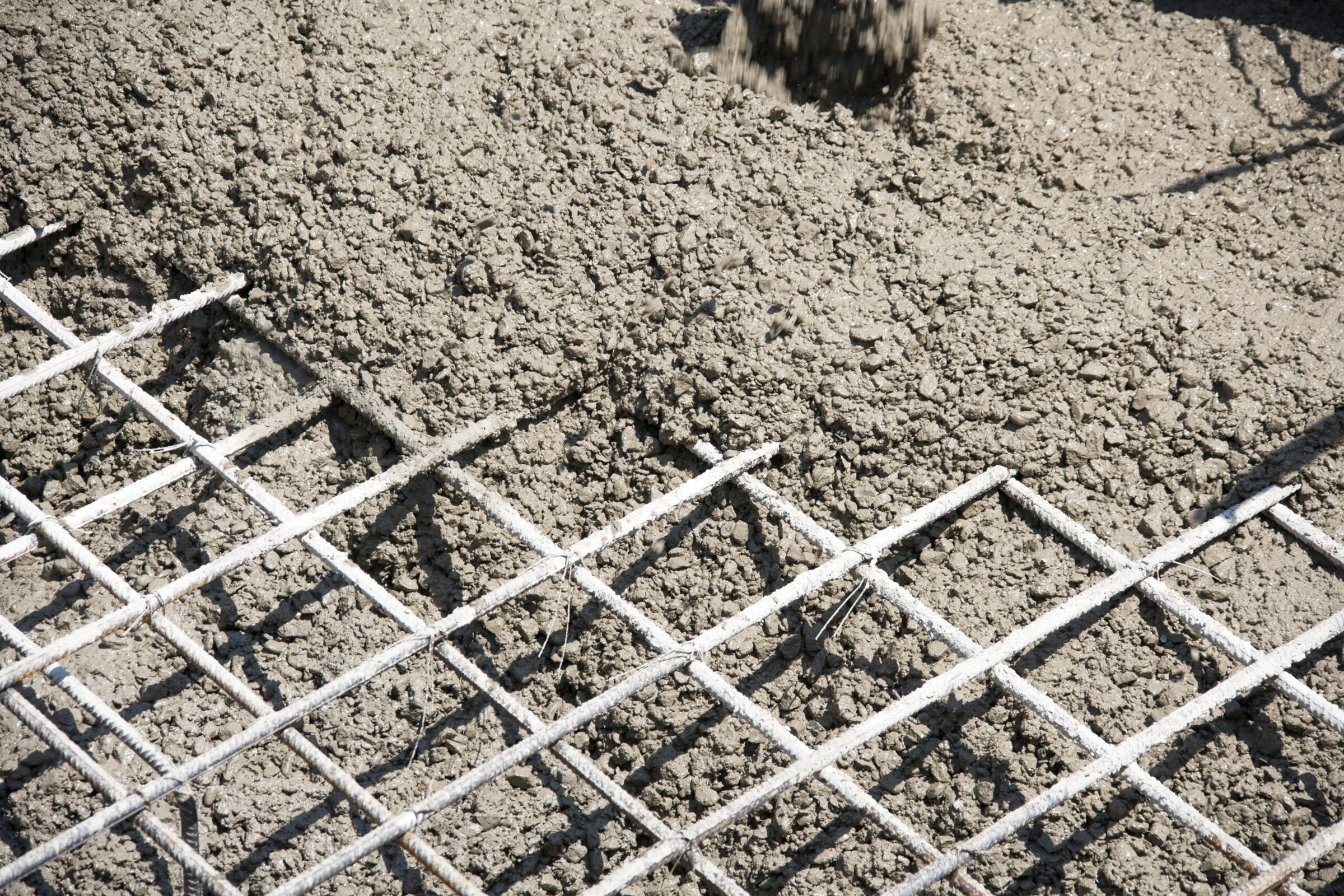 Reinforced concrete construction with steel rebar mesh on a gravel base.