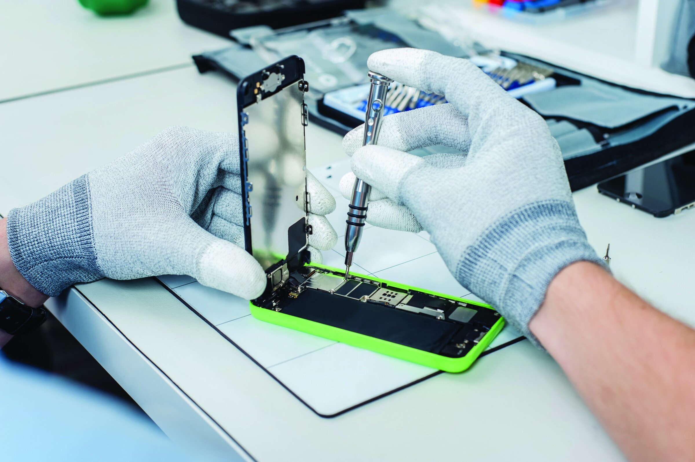 Person's hands fixing the inside of a smartphone