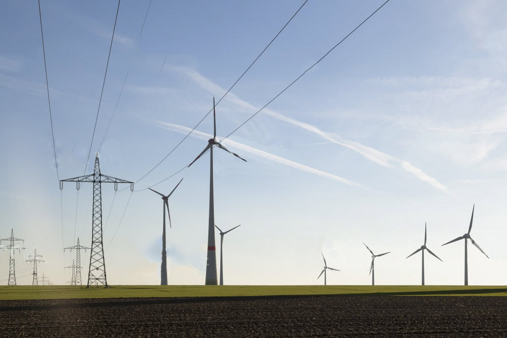 Wind turbines and power lines in a renewable energy wind farm for sustainable energy production.