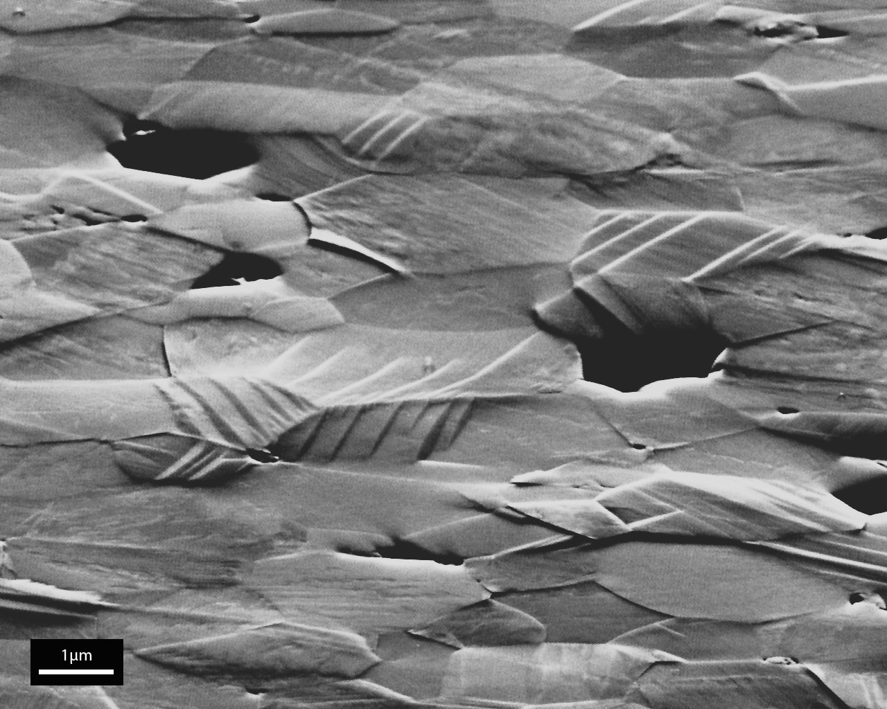 Microscopic view of ceramic material's surface structure, highlighting texture and crack patterns for ceramics research.