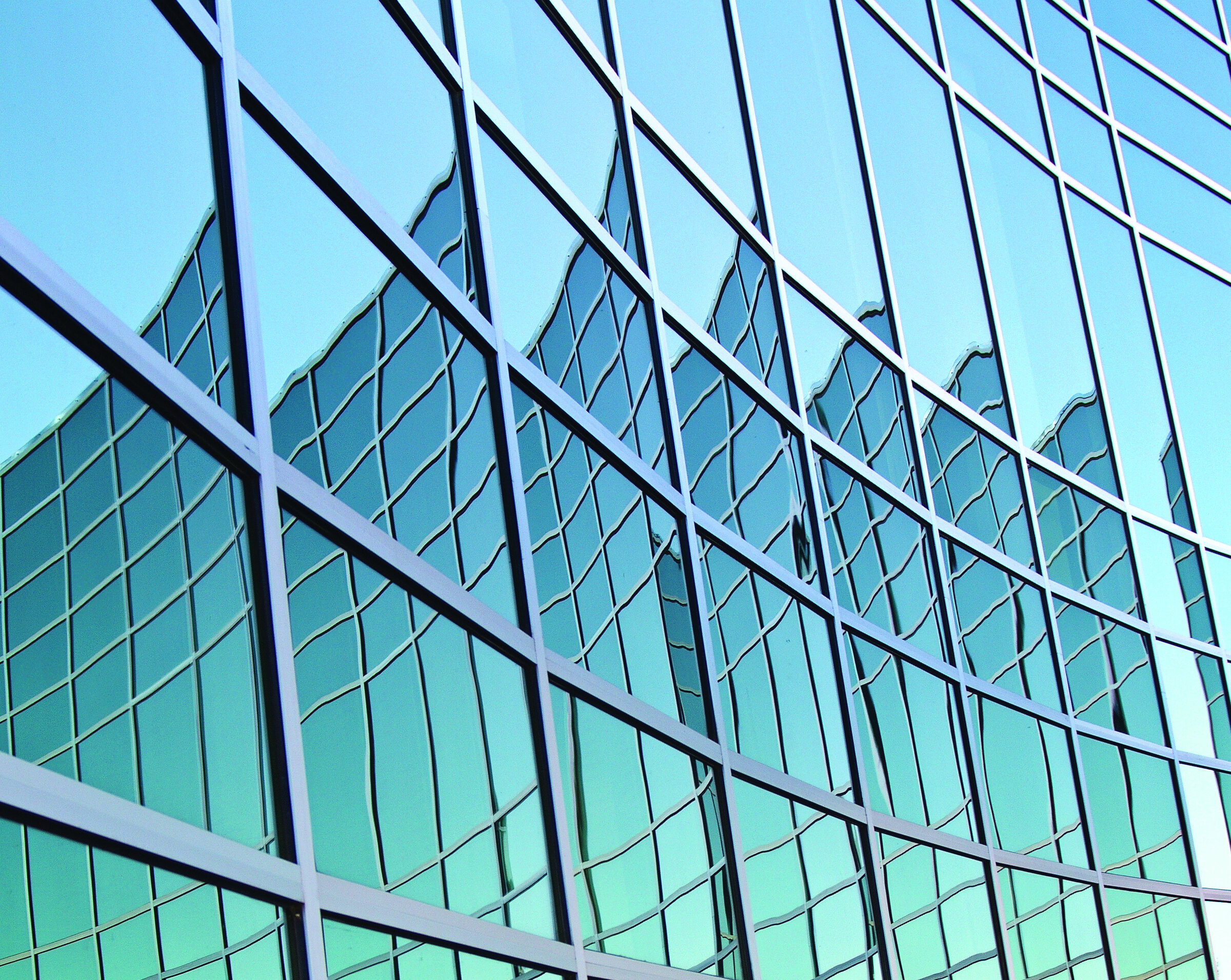Shiny glass building exterior with reflective windows, modern architecture, and geometric design.