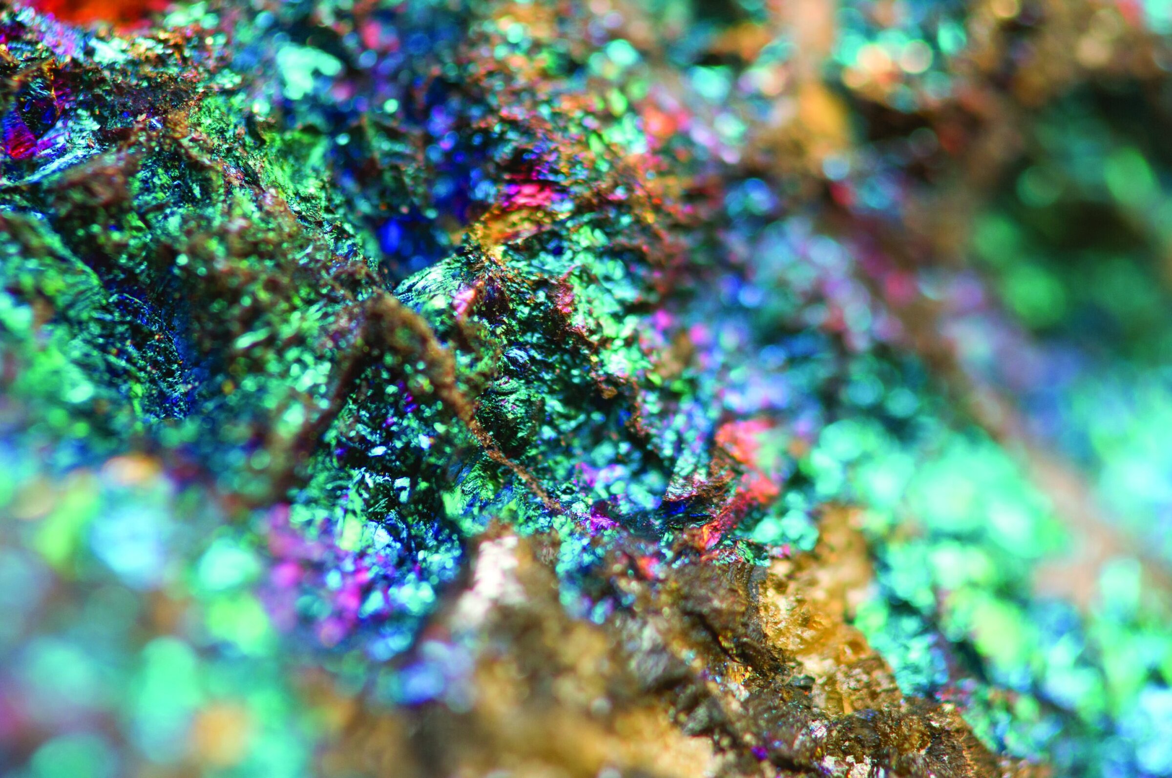 Vibrant iridescent colors on mineral surface showing optical effects and intricate details.