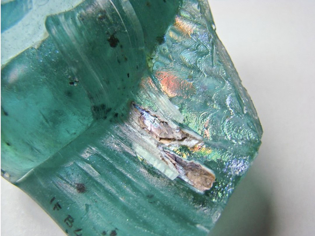 Cracked glazed ceramic piece with iridescent colors, high-resolution close-up for ceramics research.