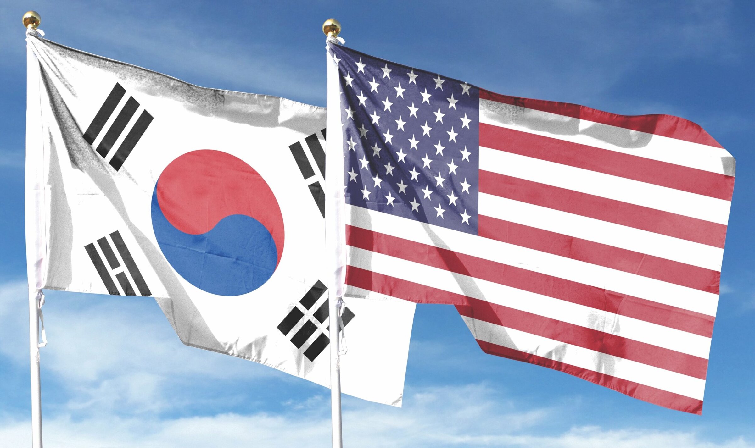 U.S. flag and Republic of Korea flag on cloudy sky.