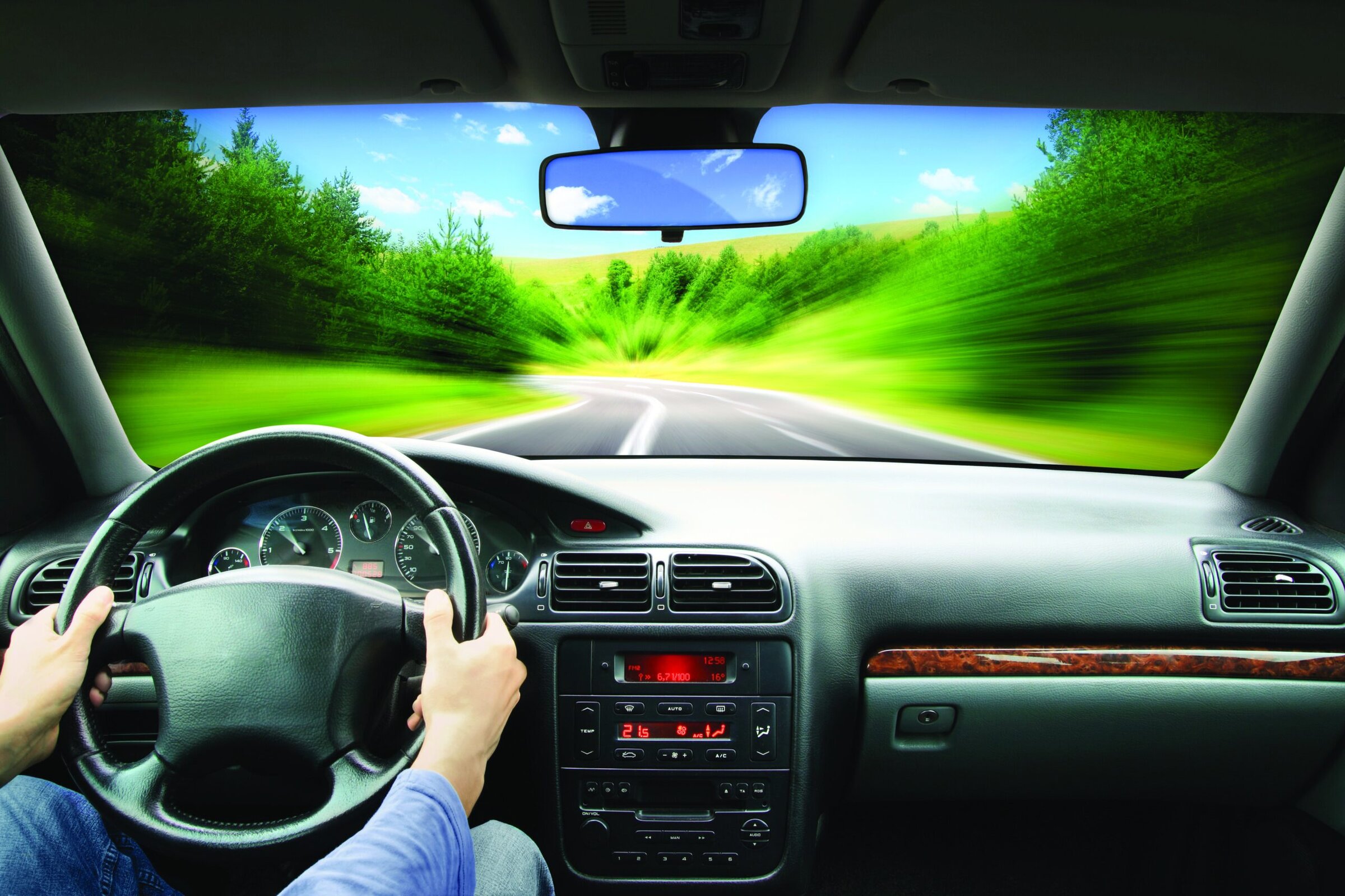 Blurry motion effect, road trip, driving through lush greenery, traveling in a car, scenic outdoor drive.