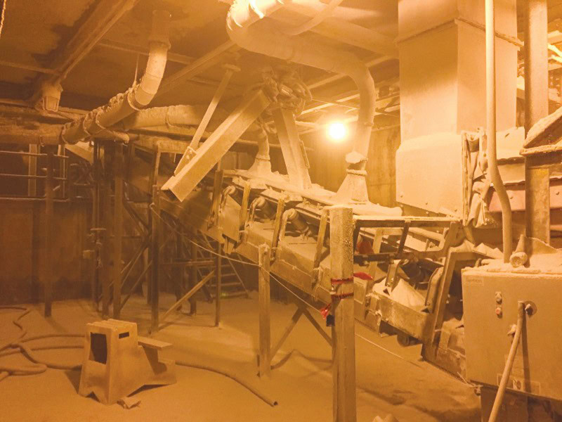 Refinery machinery covered in dust in ceramics factory.