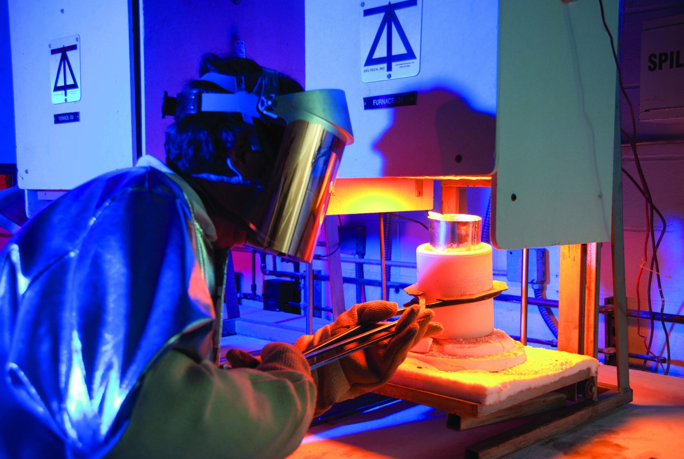 Ceramics researcher working with high-temperature furnace in ceramics lab.