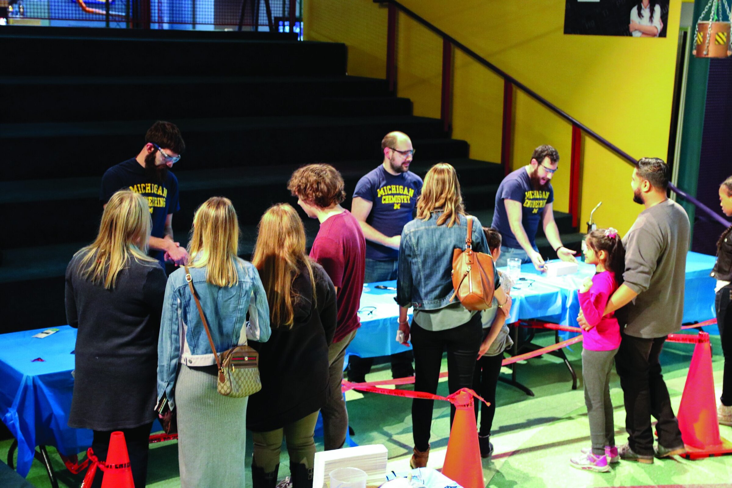 Students engaging with ceramic science activities at ACerS Bulletin event in a vibrant indoor setting.