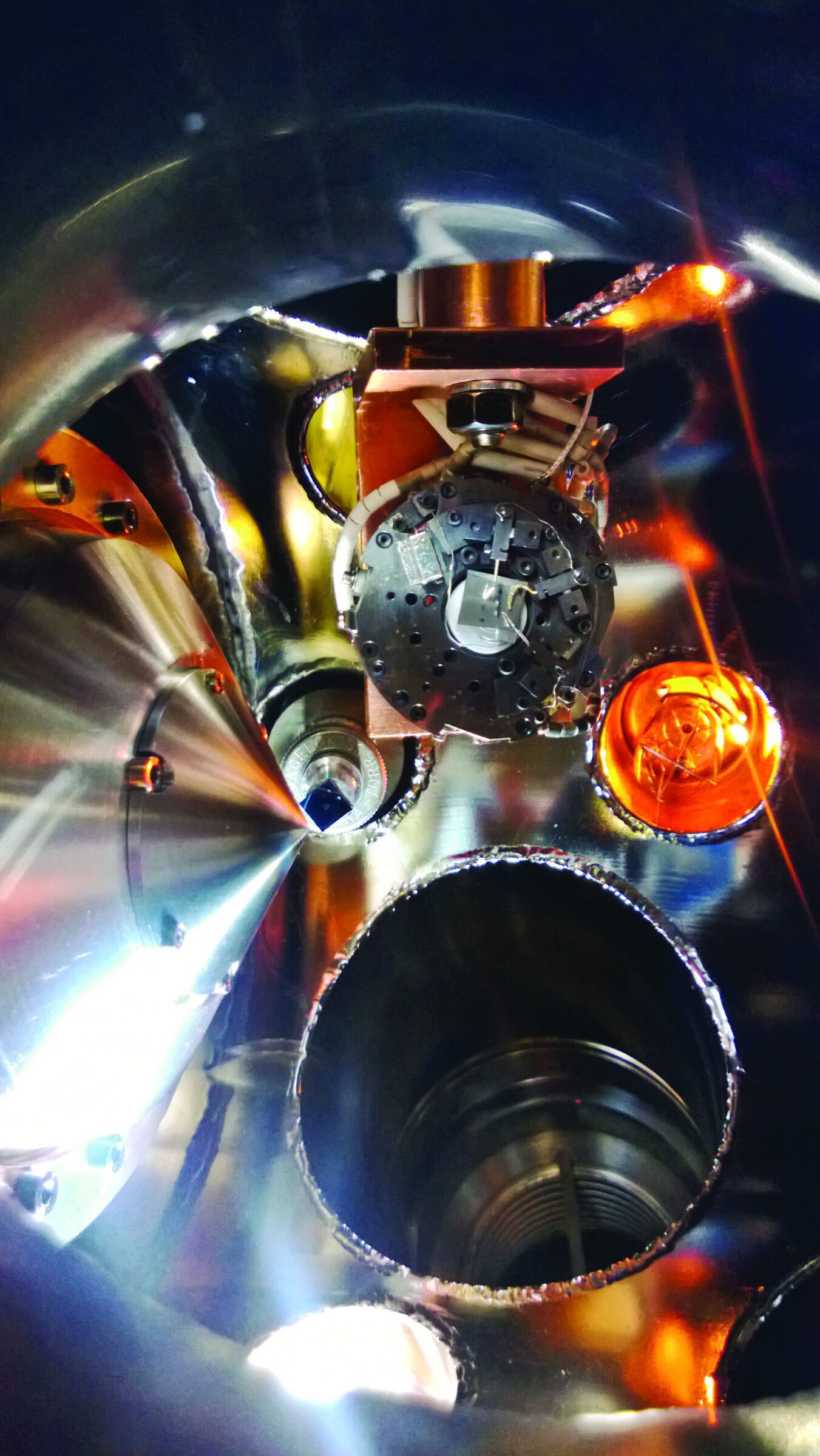 Intricate metal machinery inside a vacuum chamber, possibly related to NSF ceramics research.