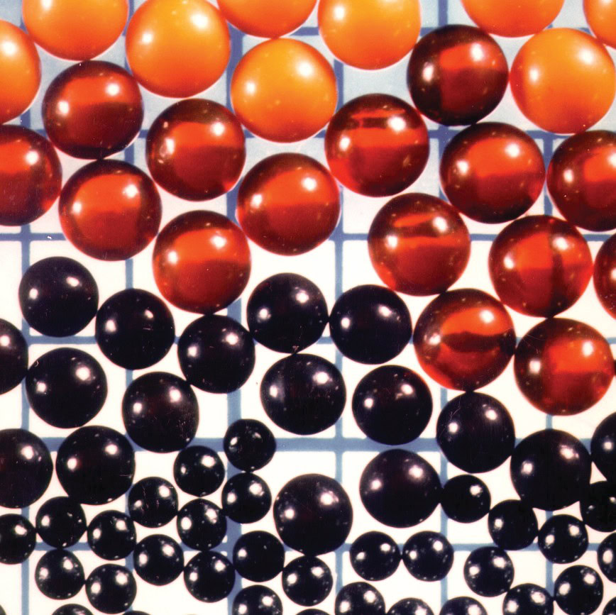Colorful ceramic glaze balls on a grid display for ceramic art and material testing.