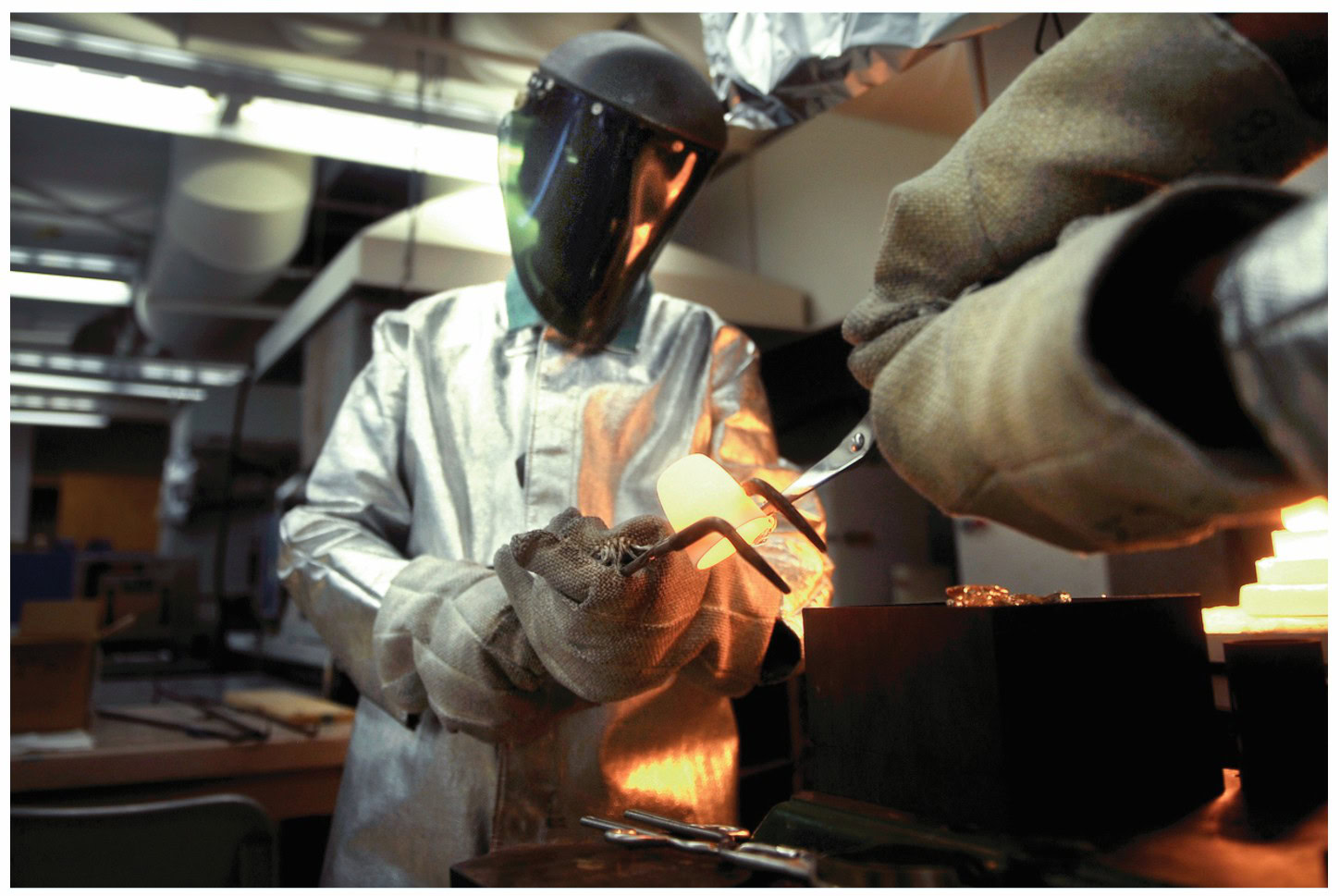 Advanced ceramic welding with protective gear in a laboratory setting.