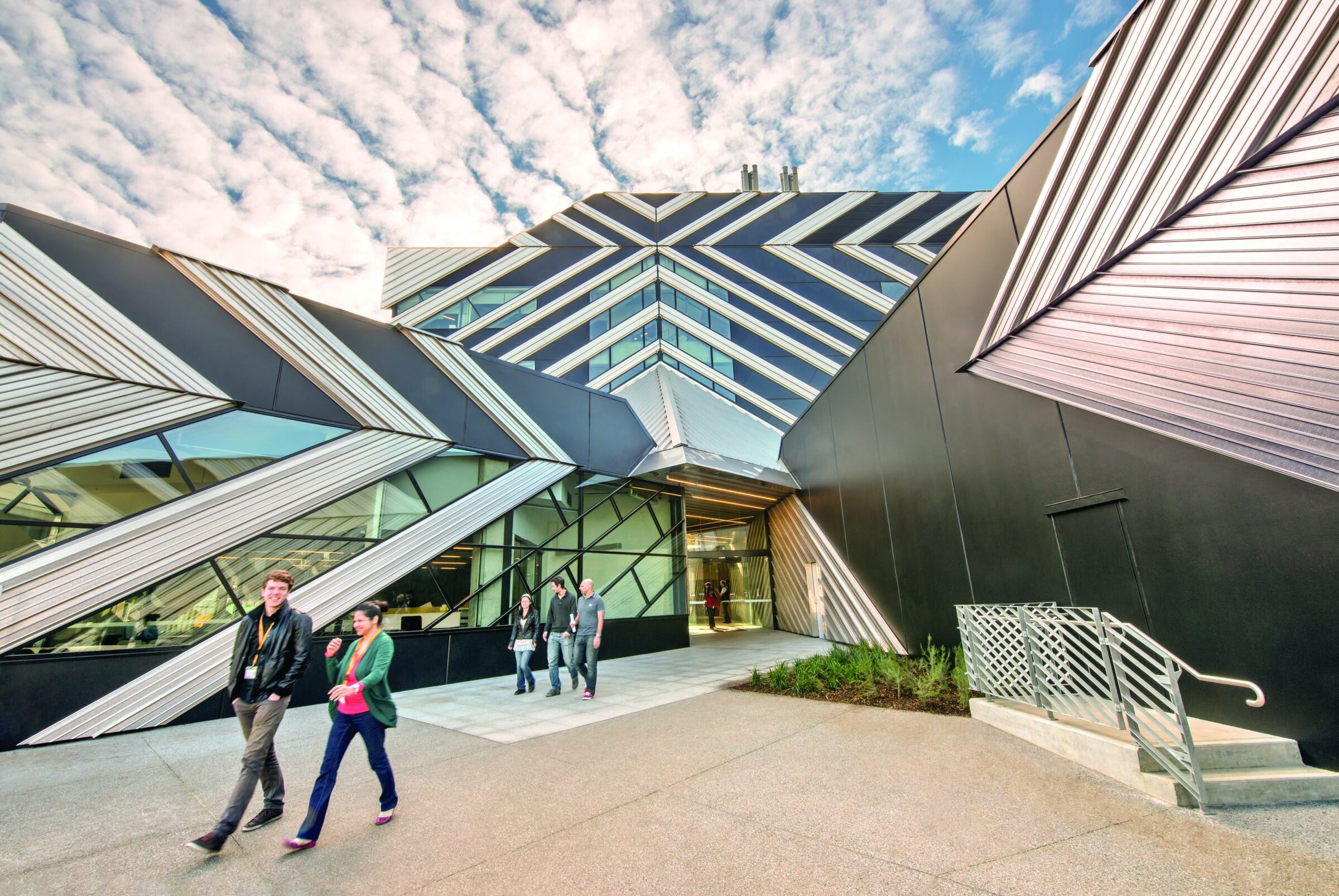 Futuristic ceramic-inspired building exterior with geometric patterns, glass, and metal elements.