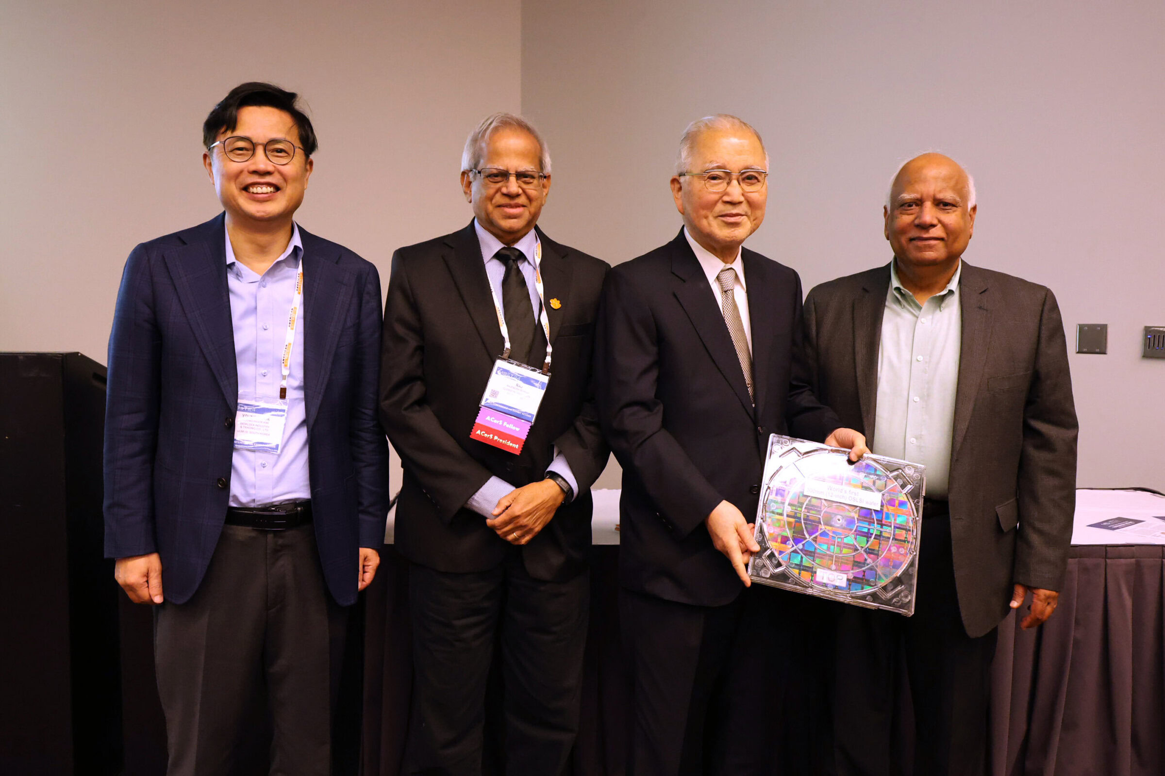 Four men in business attire accepting an award at a ceramics banquet.