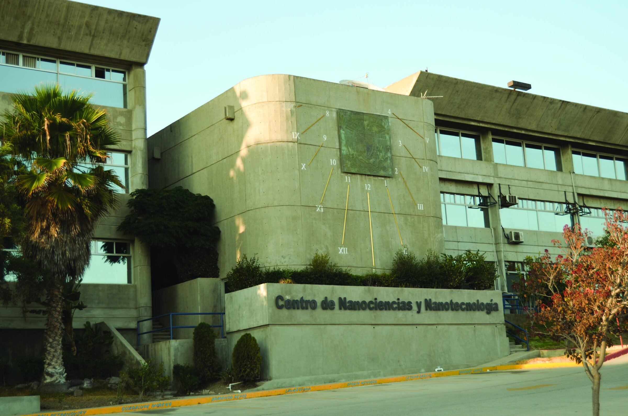 Modern concrete building with a large clock face and the inscription "Centro de Nanociencias y Nanotecnologia".