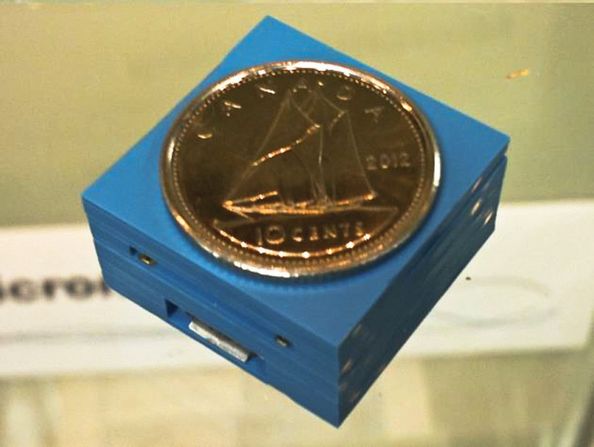 A blue device with a copper coin depicting a sailing ship on top.